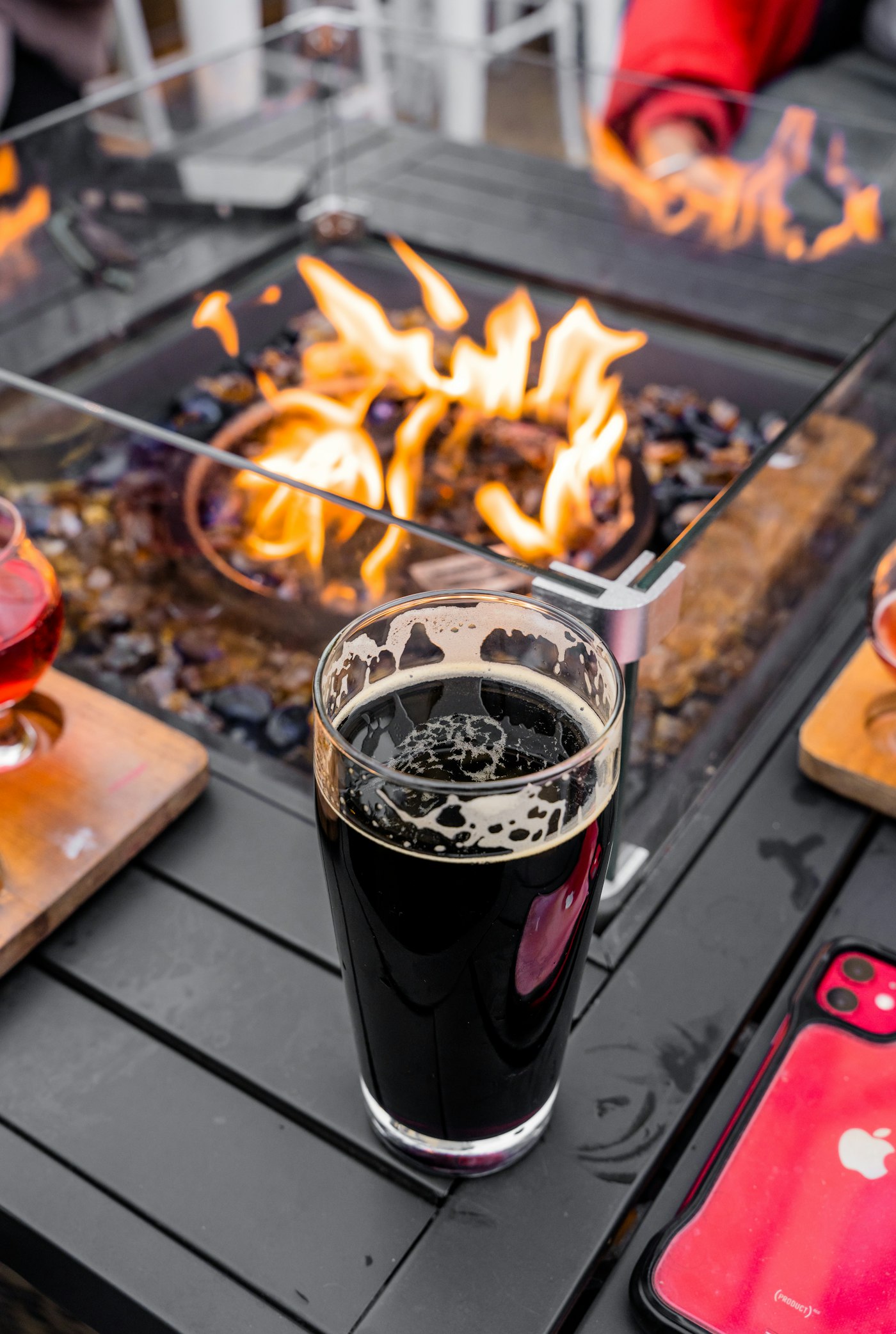 A pint of black imperial stout on a fire-table at night