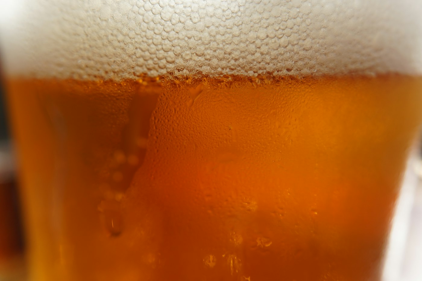 Close-up of a golden amber beer with a tight white head